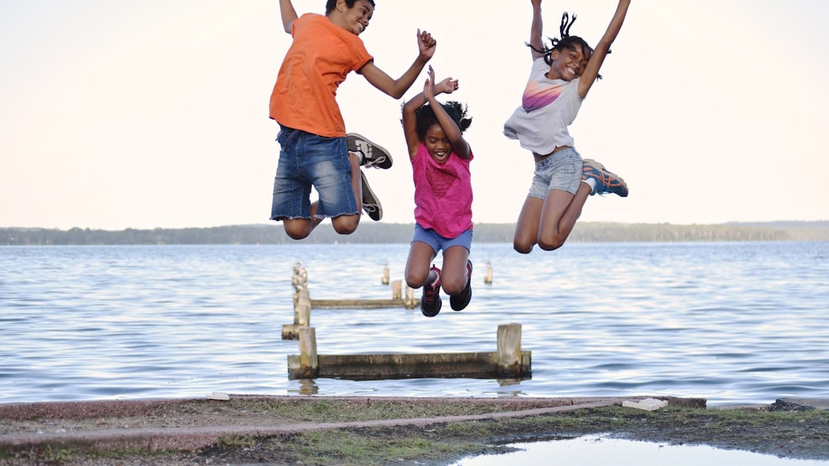 a group of people jumping on a dock