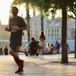 man in black crew neck t-shirt and gray shorts running on street during daytime