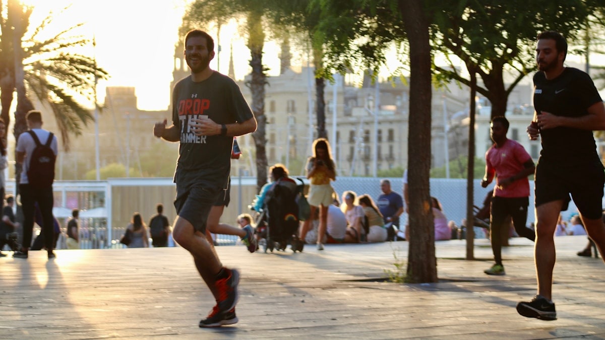 man in black crew neck t-shirt and gray shorts running on street during daytime